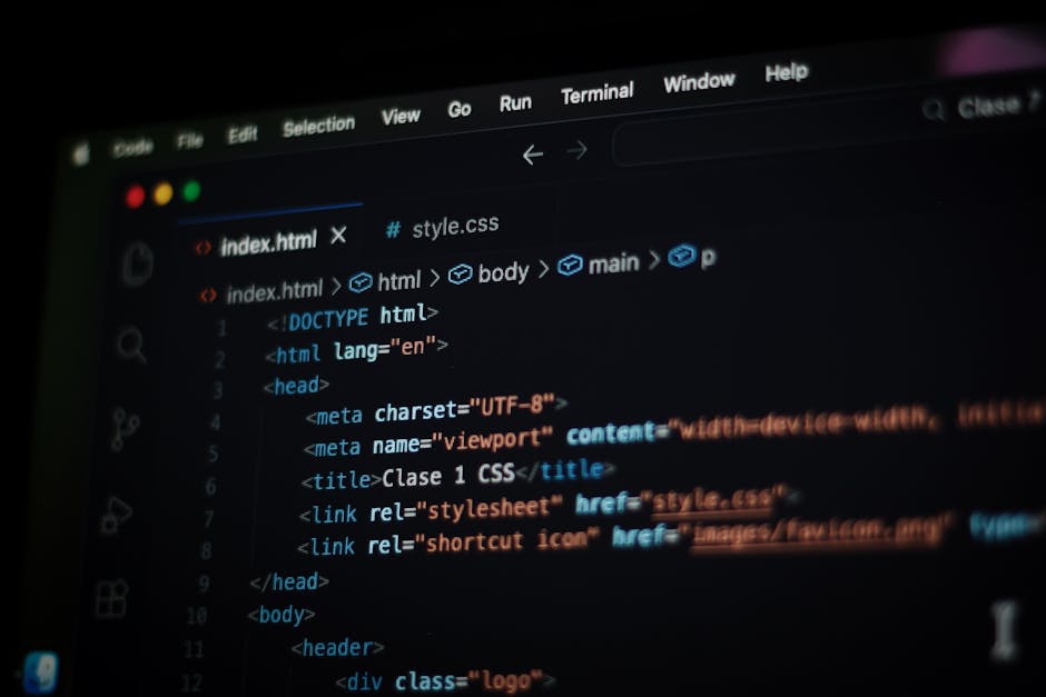 A close-up view of a laptop screen displaying lines of code in a text editor. The code includes syntax highlighting with various colors such as blue, green, and red. The laptop is placed on a surface